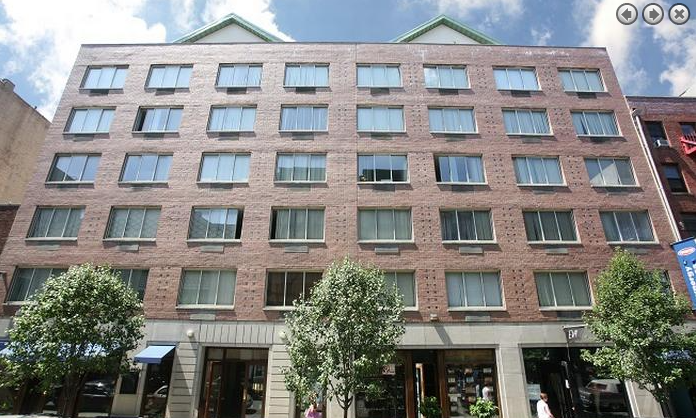 a tall brick building with trees in front of it